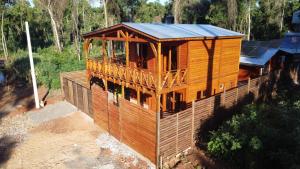 a wooden house in the middle of a forest at Encantos del Monte in Gobernador Roca +30 photos