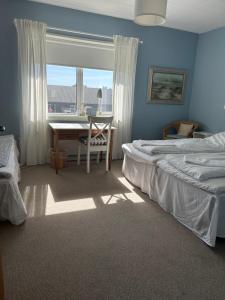 a bedroom with a bed and a table and a window at Hotel Strandlyst Badehotel in Hirtshals +30 photos
