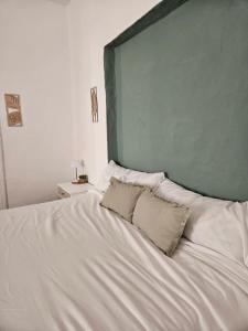 a large white bed with two pillows on it at La Bohème in Antequera