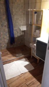 a bathroom with a shower with a wooden floor at Love Tiny House in Faro