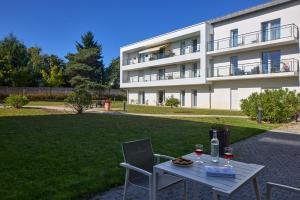 a table with two glasses of wine and a building at Quality Aparthotel Orleans Sud Zenith in Olivet