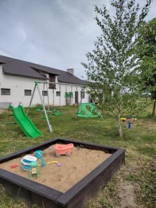 a sandbox with toys in the sand in a yard at Siedlisko Jelonki in Urowo