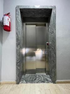 a metal elevator door in a building with a red bag at Hotel Aleksi Velipojë in Velipojë