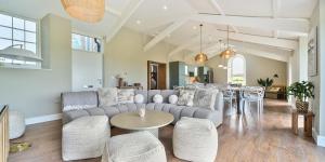 a living room with a couch and a table at Brock's Beach House in Saint Gennys