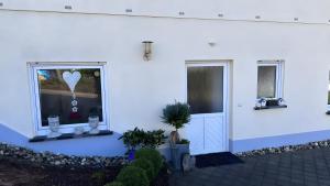 a white building with two windows and a heart decoration at Ruhige Fewo Hinzweiler in Hinzweiler