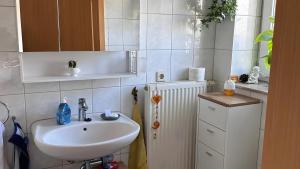 a white bathroom with a sink and a radiator at Ruhige Fewo Hinzweiler in Hinzweiler