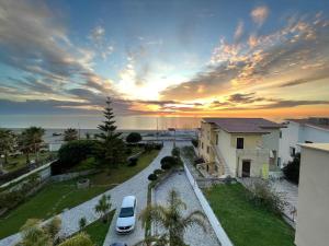 a sunset over a street with cars parked in front of a building at Citrarium B&B - Apartaments in Cetraro