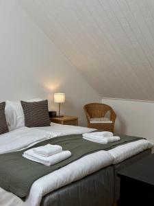 a bedroom with a bed with two towels on it at Lilla Hotellet Blidö in Blidö