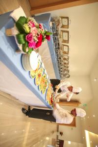 a group of people standing around a table with flowers at Tanuma Aram Hospitality - Hotel Apartments in Tanomah