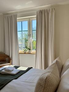 a bedroom with a bed and a window with curtains at Lilla Hotellet Blidö in Blidö +20 photos