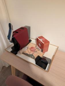 a desk with a box and a suitcase on it at Chambre ELENA in La Crau