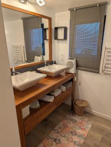 a bathroom with two sinks and a mirror at Chambre ELENA in La Crau