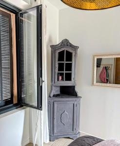 a gray cabinet in a room next to a window at Chambre ELENA in La Crau
