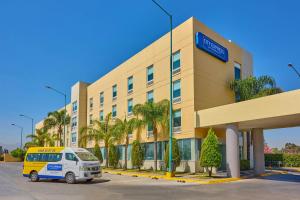 a yellow and white van parked in front of a building at City Express by Marriott San Luis Potosi Zona Industrial in San Luis Potosí