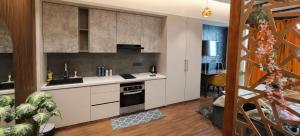 a kitchen with white cabinets and a stove at Darshana Studios#Galaxyblue sapphire#Stylish in Ghaziabad
