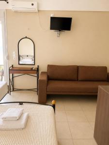 a living room with a couch and a table at PNOÉ rooms in Ilia