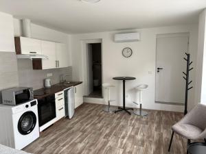a kitchen with white cabinets and a table in it at Studio U Martina in Mariánské Lázně