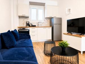 a living room with a blue couch and a kitchen at Pool Access Danai 15,1 in Ofrínion +1 photo