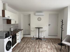 a kitchen with white cabinets and a table in it at Studio U Martina in Mariánské Lázně