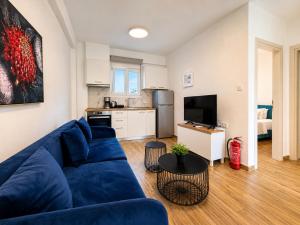 a living room with a blue couch and a kitchen at Pool Access Danai 15,1 in Ofrínion