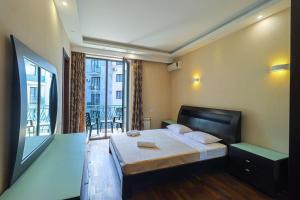 a bedroom with a large bed and a balcony at Spacious Sololaki 2BR with Balcony - by Wehost in Tbilisi City