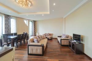 a living room with a couch and a table and chairs at Spacious Sololaki 2BR with Balcony - by Wehost in Tbilisi City