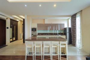 a kitchen with a island with white stools at Spacious Sololaki 2BR with Balcony - by Wehost in Tbilisi City