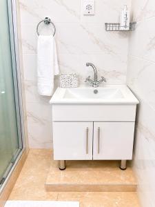 a white bathroom with a sink and a shower at Wilo Residence in Victoria Falls +41 photos