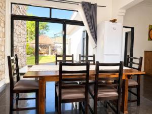 a dining room with a wooden table and chairs at Wilo Residence in Victoria Falls