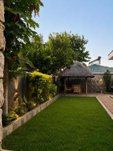a garden with a gazebo and a lawn at Wilo Residence in Victoria Falls