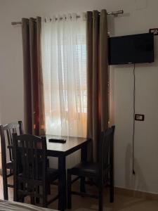 a dining room with a table and chairs and a television at Hotel Aleksi Velipojë in Velipojë +14 photos