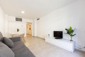 a living room with a couch and a flat screen tv at Rentalmar Sol de España - Mas d'en Gran in Cambrils