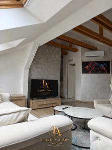 a living room with white furniture and a fireplace at Luxury Apartments in Brčko
