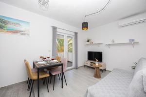 a living room with a table and a bed and a television at Apartments Milas in Okrug Gornji