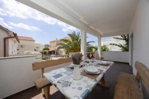 a dining table on a balcony with a view at Apartments Milas in Okrug Gornji