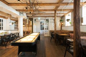 a ping pong table in a restaurant with tables and chairs at Hotel Skt. Annæ in Copenhagen