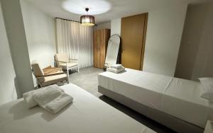 a bedroom with a bed and a mirror and a chair at Athos Villas in Ouranoupoli +140 photos