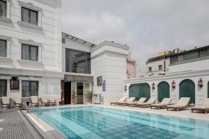 a hotel swimming pool with chairs and a building at Sura Concept Hotel in Istanbul