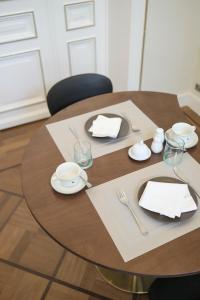 a wooden table with plates and napkins on it at Bed & Breakfast La Linière in Brussels