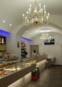 a bakery with a chandelier and a display case at I Borbone in Caserta