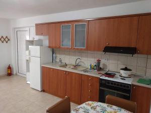 a kitchen with wooden cabinets and a white refrigerator at Almond Apartments Ground Floor Apt in Ofrínion