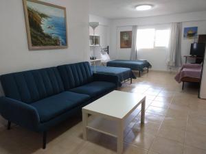 a living room with a blue couch and a table at Almond Apartments Ground Floor Apt in Ofrínion