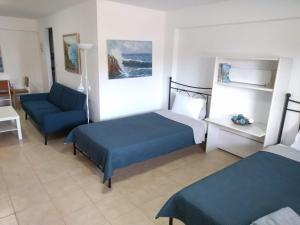 a hotel room with two beds and a chair at Almond Apartments Ground Floor Apt in Ofrínion