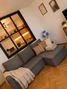 a couch in a living room with a large window at Studio Słowackiego in Września +1 photo