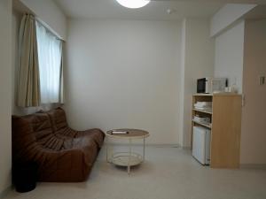 a living room with a couch and a table at attomi hostel 2 in Sapporo