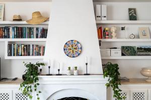 a fireplace in a living room with bookshelves at Casa Pueblo Lopez in Fuengirola