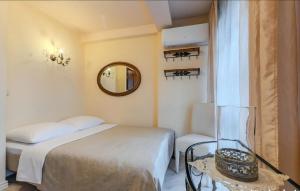 a small bedroom with a bed and a mirror at Willa Ahava in Kazimierz Dolny