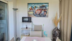 a room with a picture of an old car on the wall at La Rose des Sables - face à la mer in Frontignan