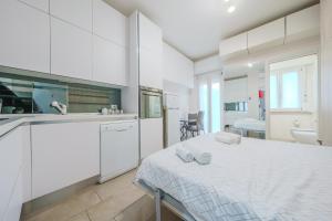 a white kitchen with a bed in a room at Cristel Apartment - 15 min da Milano in Cormano