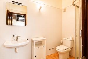 a white bathroom with a sink and a toilet at Tejasturias |Piscina, Pádel y Playa de La Franca in Noriega +21 photos